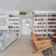 Foto de apartamento com estante cheia de livros, sofás e poltronas