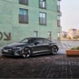 No Audi RS e-tron GT em frente a um prédio de tijolos verdes