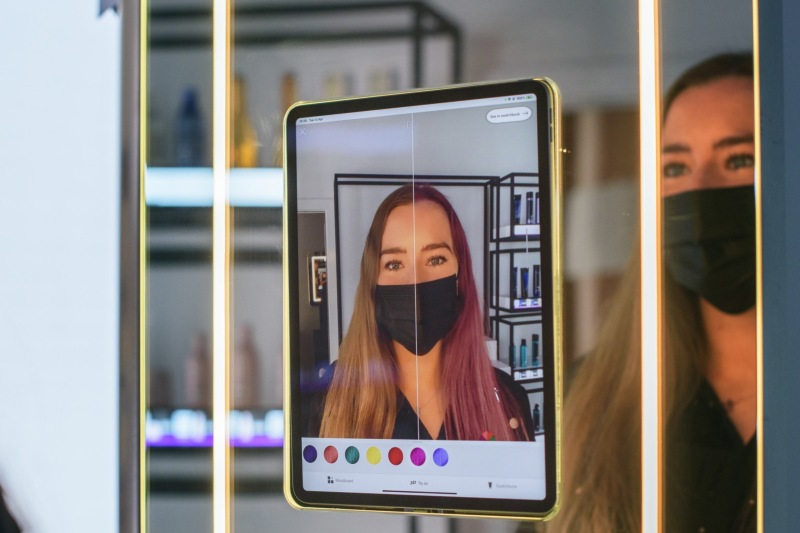 Tablet exibindo tecnologia de de realidade aumentada que permite experimentar cores de cabelo virtuais por meio