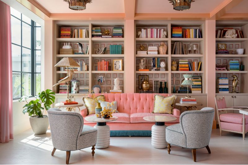 Sala com livros com tons de pêssego brilhante e revestida de carvalho natural