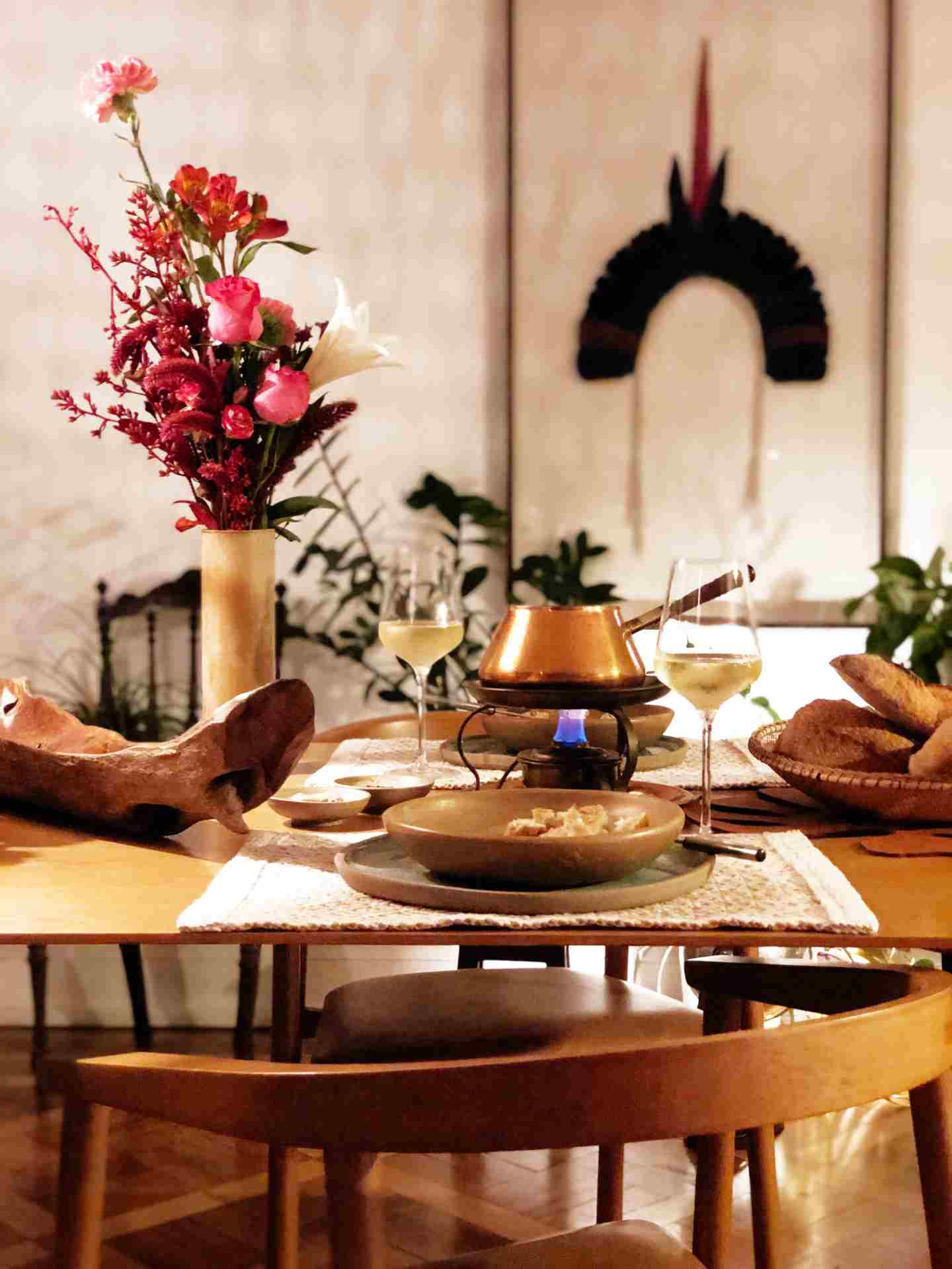 Mesa posta com pratos, taças de vinho e fondue 