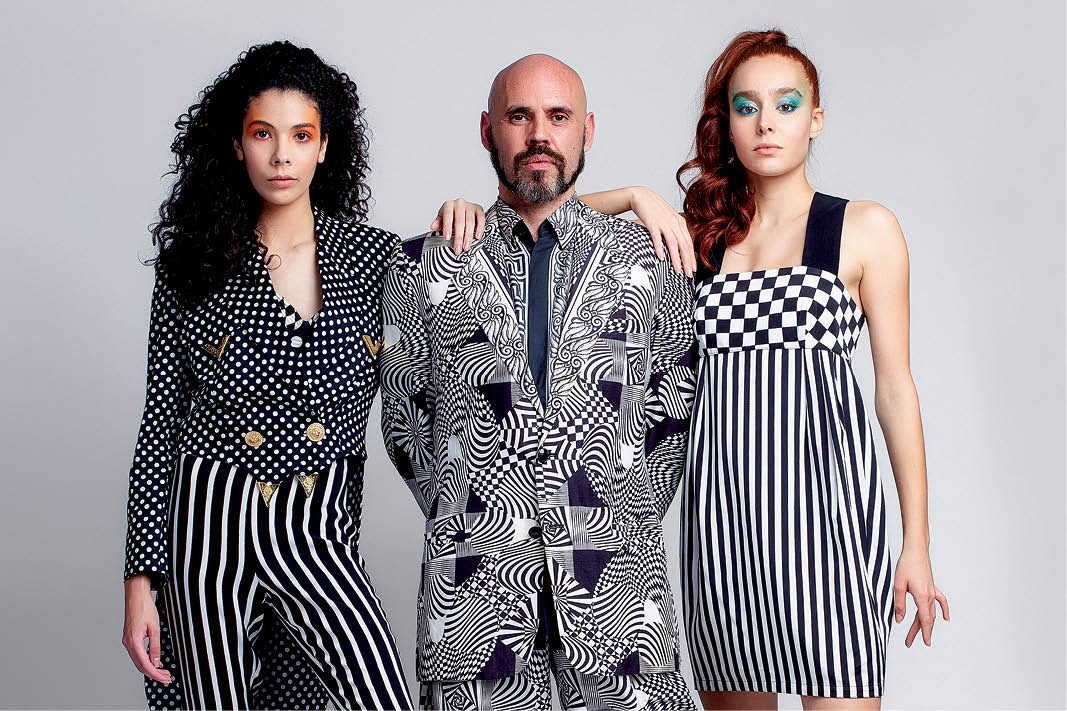 Em editorial, Alexandre Stefani posa ao lado das modelos Bruna Monrine (à esq.) e Laura Iside (à dir.) com peças Versace