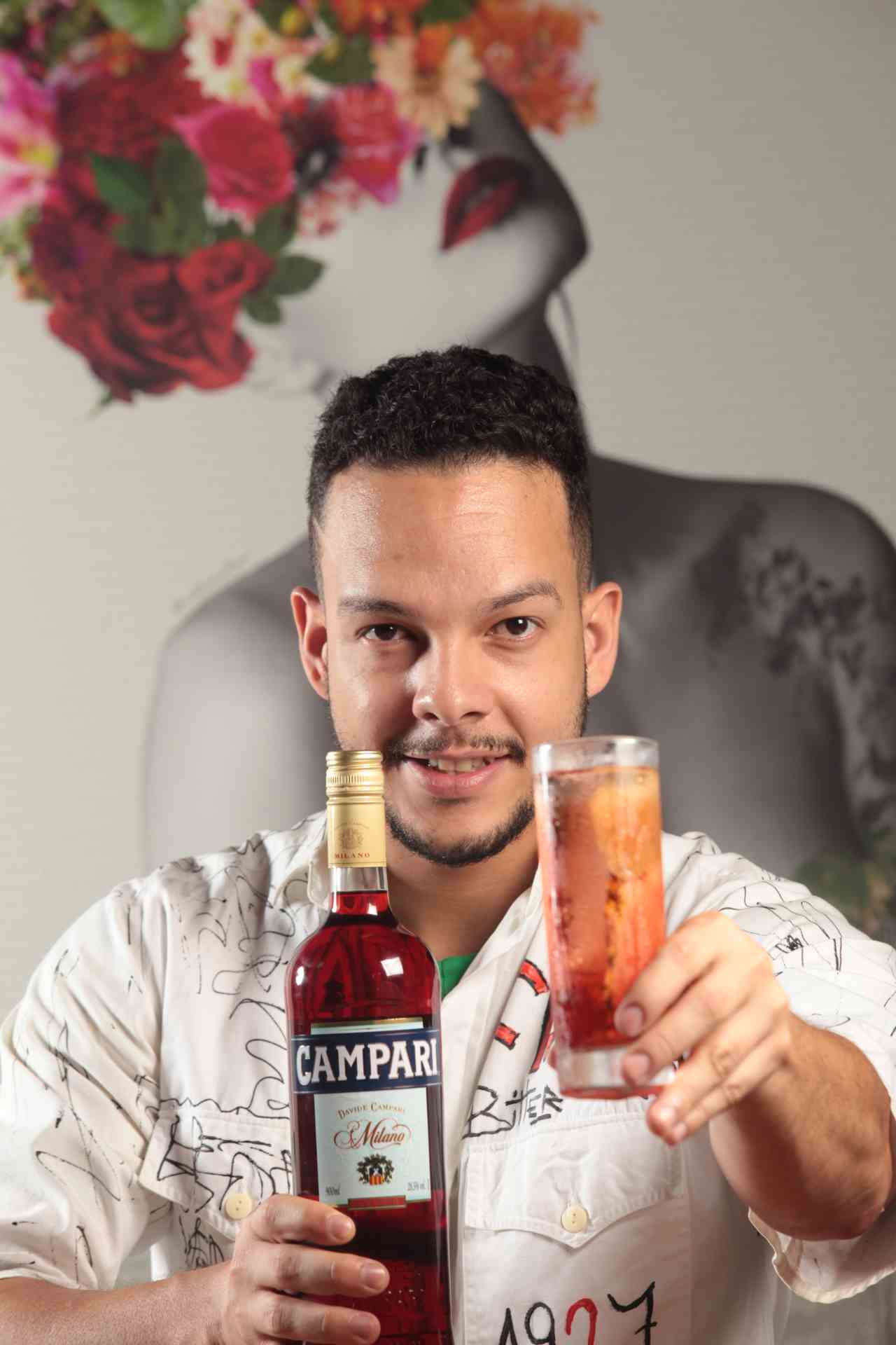 Igor Renovato segura uma garrafa de Negroni e um copo com drink preparado com a bebida