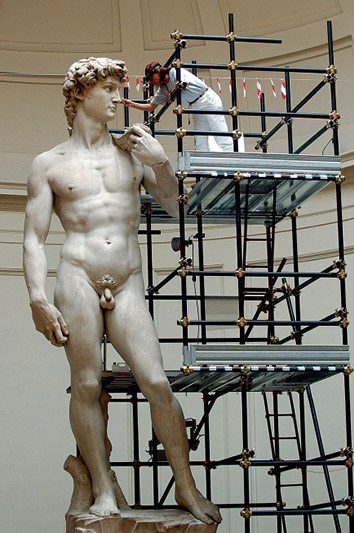 Profissional higienizando e restaurando a escultura Davi em um dos museus de Florença, a Galeria da Academia de Belas-Artes 