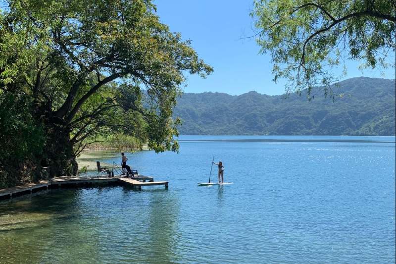 Pessoas fazendo stand up paddle no lago