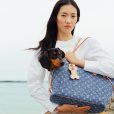 Modelo carrega bolsa Louis Vuitton à beira mar